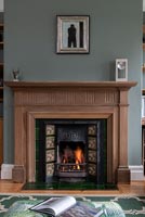 Detail of wooden fire surround and lit fire 