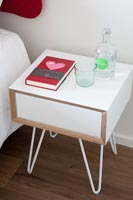 Small bedside cabinet with drink of water and romantic book 