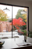 View from dining room through to garden and autumnal trees 