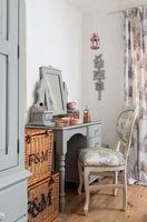 Modern bedroom with painted dressing table and vintage chair 