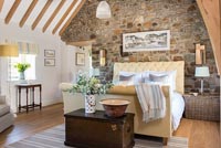 Country bedroom with exposed stone wall 