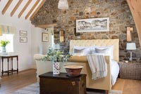 Country bedroom with exposed stone wall 