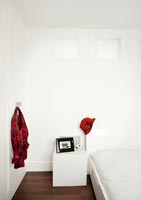 Splashes of red in white modern bedroom 