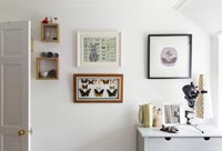 Framed art and butterflies on bedroom wall 
