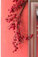 Red berry decoration against red painted wall 