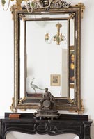 Gilt mirror above a mantelpiece 