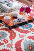 Tray for tea on modern colourful fabric covered table