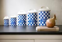 Row of blue and white storage jars on kitchen worktop 