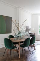 Modern dining table with green chairs in Georgian living room