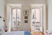 Open French windows in classic bedroom with balcony 