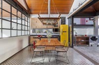 Modern industrial kitchen-diner with bifold doors to barbecue area  