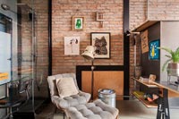 Modern industrial open plan apartment with exposed brick wall and shower cubicle 