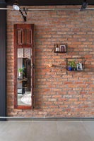 Old mirrored wooden wardrobe door mounted on brick wall 