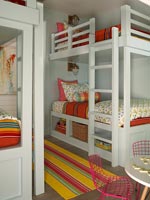 Bunk beds in childrens room with colourful bedding 