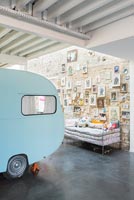 Display of pictures on stone wall and vintage caravan in childrens room 