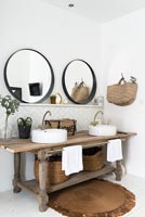 Wooden table with twin sinks and mirrors in modern country bathroom 