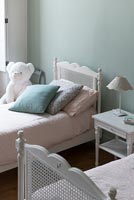 Pastel cushions on childrens bed 