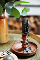 Melted black candle in wooden candle holder 