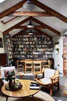 Open plan living and dining area with bookcase wall 