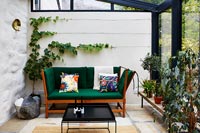 Green sofa in modern conservatory 