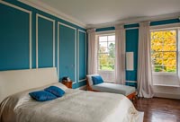Master bedroom with blue painted paneled wall
