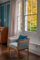 Striped antique chair by window in classic bedroom 
