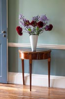 Flower arrangement on antique wooden console table 