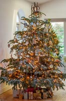 Large decorated Christmas tree with fairy lights and gifts 
