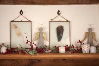 Christmas decorations and framed feathers on shelf 