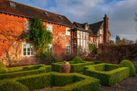 Formal parterre outside large 15th Century country house 