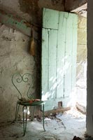 Green chair and painted rustic wooden door 
