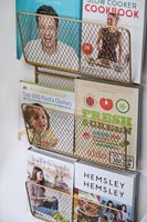 Wire wall mounted rack with recipe books in modern kitchen 