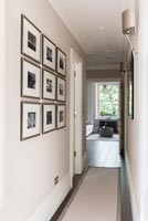Modern corridor with display of framed photographs on wall 