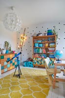 Colourful playroom with spotty feature wall and decorative lights 