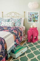Eclectic colourful bedroom with elephant shaped bedside table 