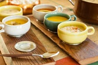 Soup in bowls on wooden trays 