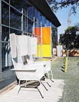 Large white wicker chairs in contemporary courtyard garden 