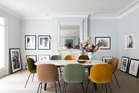 Different coloured chairs around vintage dining table 