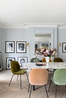 Different coloured chairs around marble dining table 