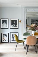 Framed black and white photographs in dining room with vintage furniture 