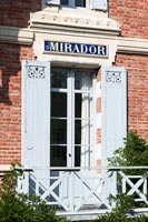 Mirador written over French windows with shutters and balcony 
