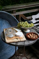 Small garden table with cheese, fruit and nuts 