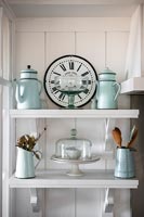 Vintage jugs and glassware on white painted shelves 