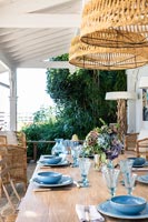 Blue crockery and glassware on outdoor dining table 