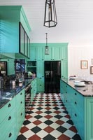 Black, white and red checkerboard flooring in mint green kitchen 