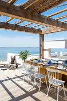 Dining area on decking overlooking the sea 