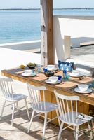 Built-in dining table on decking overlooking the sea 