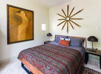 Modern bedroom with vintage sunburst mirror 