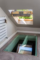 Open skylight window in roof above glass hatch in floor 