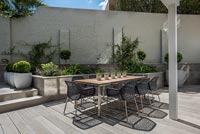 Outdoor dining area on terrace of walled courtyard garden